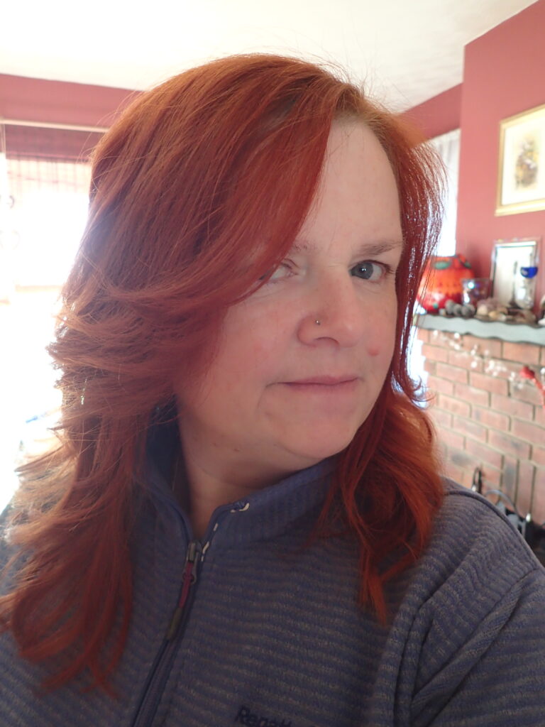 Portrait of Astara. A woman middle aged with long wavy red hair.